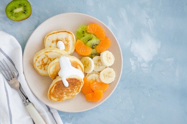 Pancakes on buttermilk or kefir with fresh fruit and yogurt on a plate