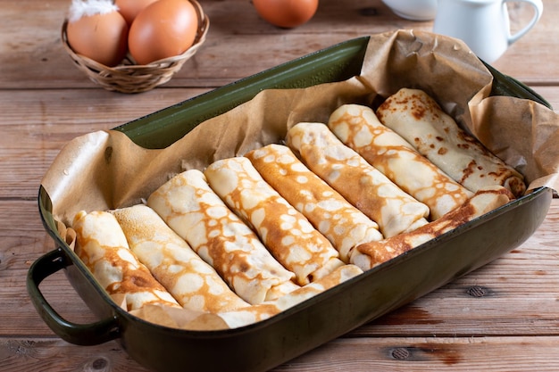 Pancakes stuffed with cottage cheese and raisins on wooden table A delicious sweet dessert