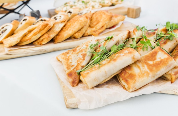 Pancakes stuffed with ham and cheese chicken and vegetables on a banquet table Horizontal photo