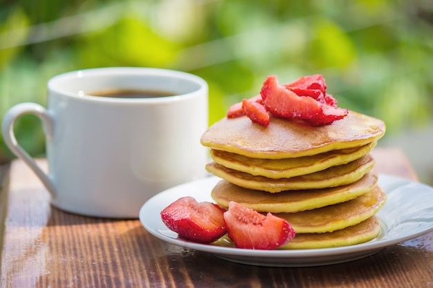 Pancakes tea and strawberry jam for breakfast