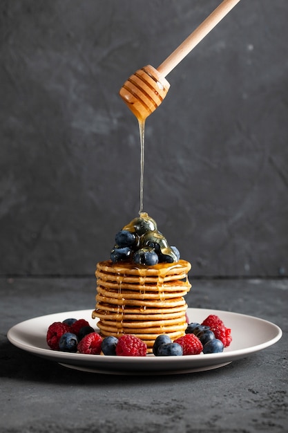 Pancakes with berries and maple syrup.