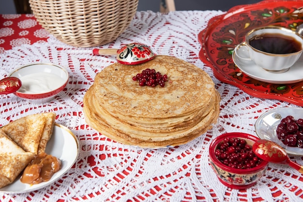 Pancakes with berries and sour cream on the table shrovetide maslenitsa festival concept