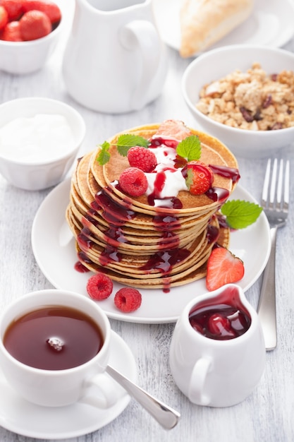 Pancakes with berry and jam for breakfast