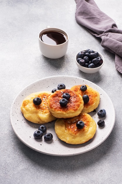 Pancakes with blueberries on a black plate