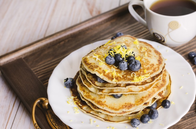 Pancakes with blueberry on white plate.