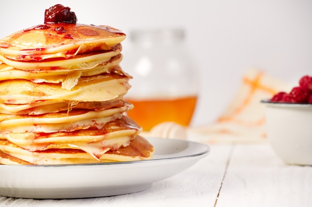 Pancakes with cherry jam on table