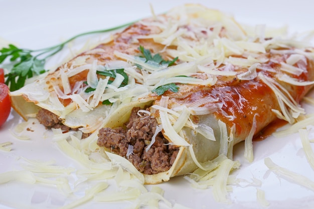 Pancakes with meat, in tomato sauce and cheese, with cilantro and grated cheese on top.