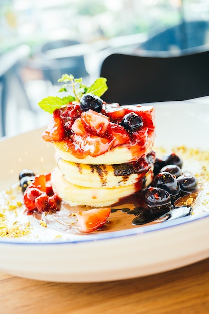 Pancakes with mixed berry fruit in white plate