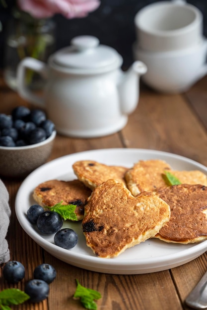 Pancakesheart shaped with fresh blueberries Morning breakfast delicious vegan pancakes Rustic woodenbackground