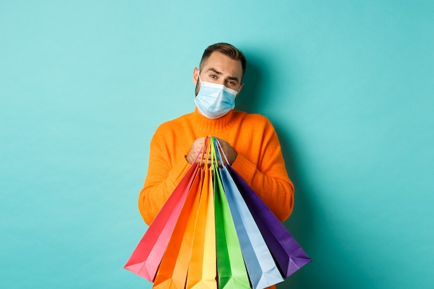 pandemic and lifestyle. Displeased and reluctant man in medical mask, holding