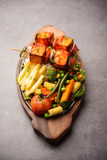 Paneer Sizzler is an Indian version with cottage cheese salad served sizzling on hot stone dish