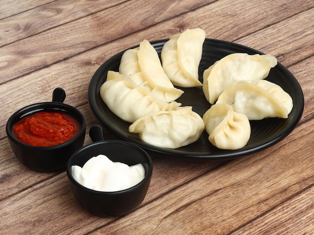 Paneer steam momo Nepalese Traditional dish Momo stuffed with paneer and then cooked and served with sauce and mayonnaise over a rustic wooden background selective focus