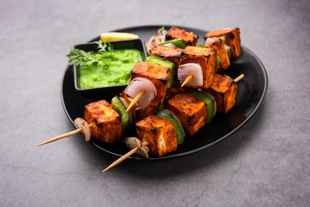 Paneer tikka is an Indian dish made from chunks of cottage cheese marinated in spices and grilled in a tandoor