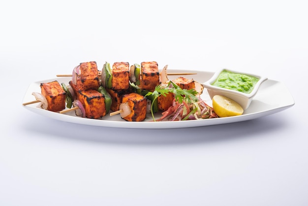 Paneer tikka is an Indian dish made from chunks of cottage cheese marinated in spices and grilled in a tandoor