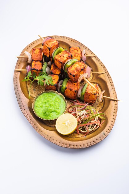 Paneer tikka is an Indian dish made from chunks of cottage cheese marinated in spices and grilled in a tandoor