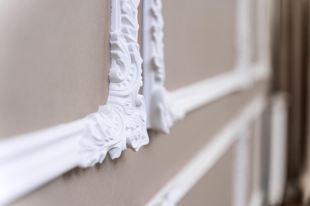 The panel is a plaster frame with patterned corners on the wall of the room Interior design Loft with baroque elements Beigebrown shades