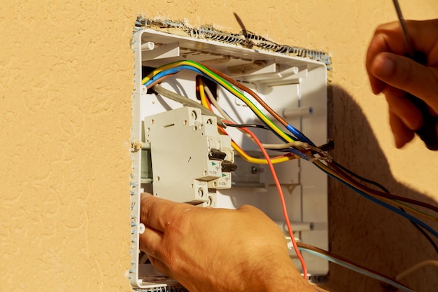 Panel with electrical equipment An electrician installs circuit breakers