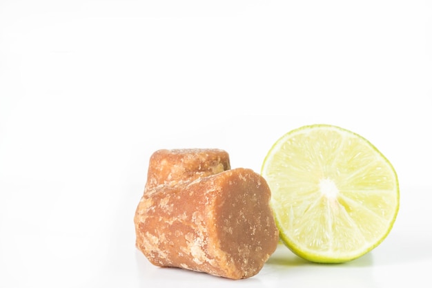 Panela cubes or sugar cane candy and lemon on a white background with copy space typical food from Colombia