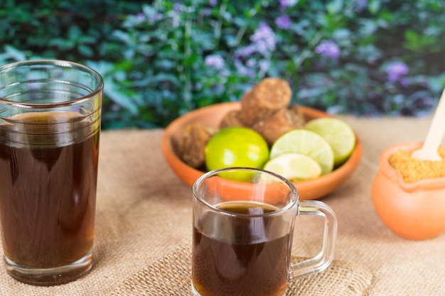 Panela granulated and agua de panela and lemon or candies made from sugar cane and lemon in nature typical food of Colombia