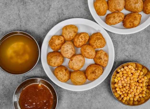 Pani puri or gol gappay with dahi chnnay spicy water chutney and sauceserved dish isolated on background top view of indian spices food