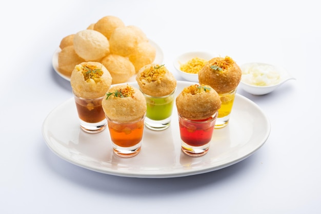 Photo panipuri shot or golgappa shots different flavours of water served in small glasses with stuffed puri indian starter snack