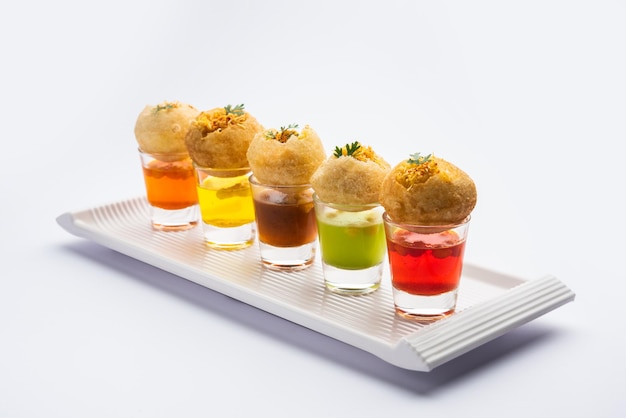 Photo panipuri shot or golgappa shots different flavours of water served in small glasses with stuffed puri indian starter snack