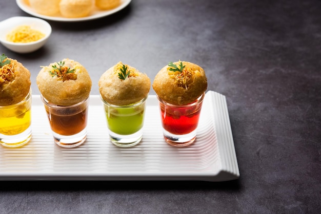 Photo panipuri shot or golgappa shots different flavours of water served in small glasses with stuffed puri indian starter snack