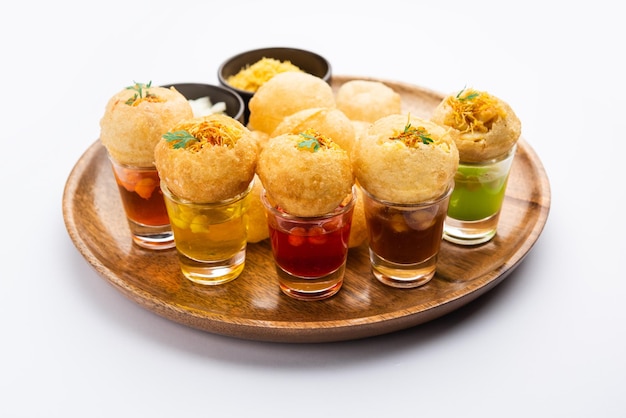 Photo panipuri shot or golgappa shots different flavours of water served in small glasses with stuffed puri indian starter snack