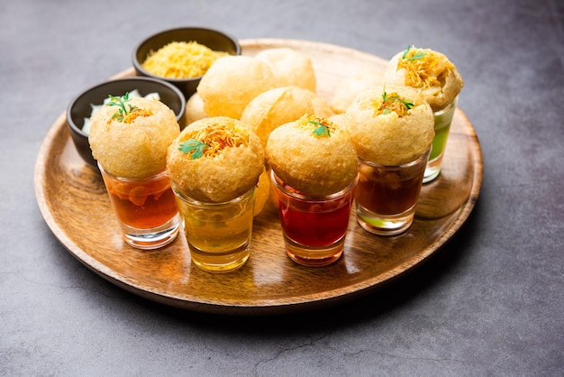 Photo panipuri shot or golgappa shots different flavours of water served in small glasses with stuffed puri indian starter snack