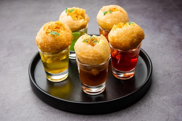 Photo panipuri shot or golgappa shots different flavours of water served in small glasses with stuffed puri indian starter snack