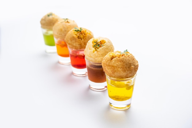 Photo panipuri shot or golgappa shots different flavours of water served in small glasses with stuffed puri indian starter snack