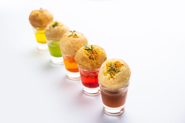 Photo panipuri shot or golgappa shots different flavours of water served in small glasses with stuffed puri indian starter snack