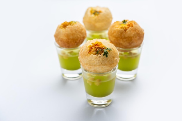 Photo panipuri shot or golgappa shots different flavours of water served in small glasses with stuffed puri indian starter snack