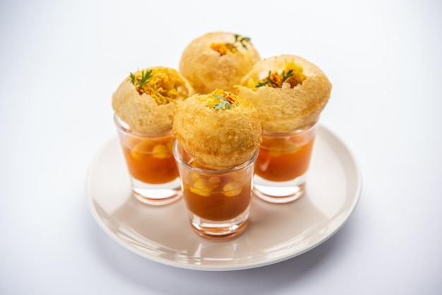 Photo panipuri shot or golgappa shots different flavours of water served in small glasses with stuffed puri indian starter snack