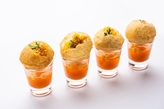 Photo panipuri shot or golgappa shots different flavours of water served in small glasses with stuffed puri indian starter snack