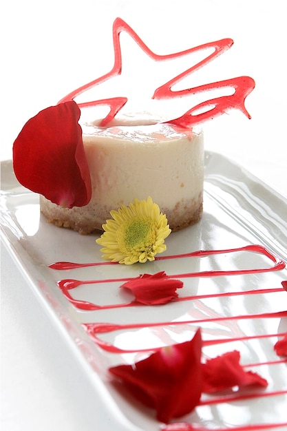 Panna cotta dessert garnished with caramel and rose petals, food on white background