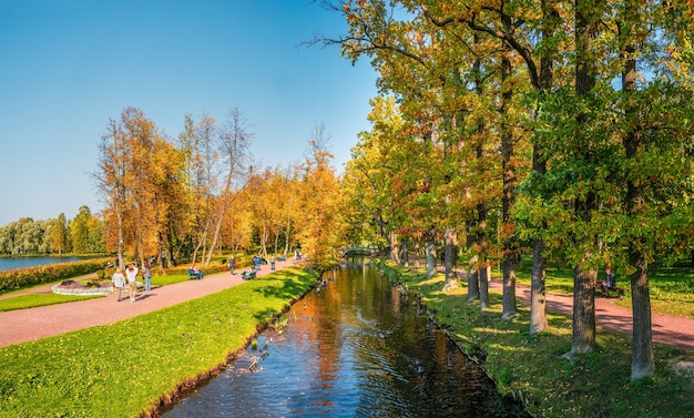 Panorama of the autumn Park with silhouettes of walking people Gatchina Russia