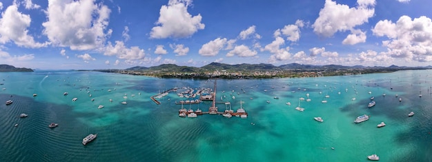 Panorama Chalong pier with sailboats and other boats at the seaBeautiful image for travel and tour website designAmazing phuket island view from drone panoramic landscapeSummer day