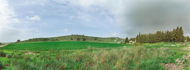 Photo panorama of a green field against a background of clouds in israel