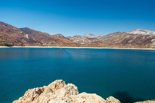 Panorama landscape of reservoir with blue water and mountains with rocks