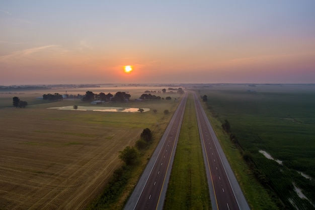 Panorama landscape view in sunrise over the meadow across high speed highway in the morning fog in the thick fog natural landscape