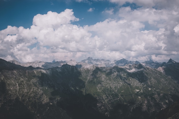 Panorama of mountains scene with dramatic cloudy sky in national park of Dombay, Caucasus, Russia. Summer landscape and sunny day