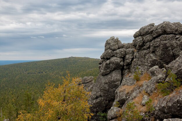 Panorama of mountains scenes in national park Kachkanar, Russia, Europe. Cloudy weather, dramatic blue color sky, far away green trees