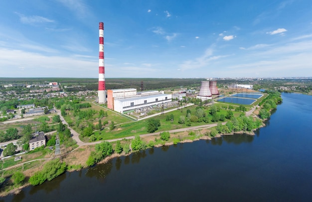 Panorama of a power plant with pipes on the lake in summer