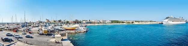 Panorama of sea port in Rhodes old town Cruise liner moored to port pier with boats on azure water