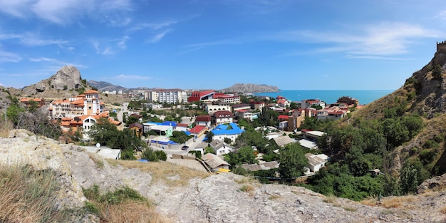 Panorama of Sudak with views of the sea and mountains in a Sunny summer day.