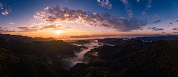 Panorama over the sunrise with blue sky background at morning time and mountain fog in the winter season  