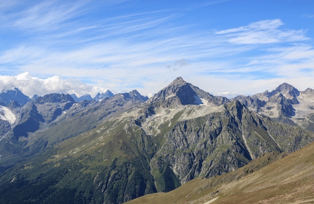 Panorama view of dramatic blue sky and mountains scene in national park Dombay, Caucasus, Russia. Summer landscape and sunny day