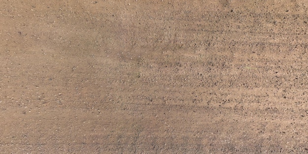 Panorama view from above on texture of gravel road with car tire tracks