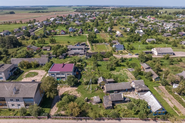 panoramic aerial view of eco village with wooden houses gravel road gardens and orchards